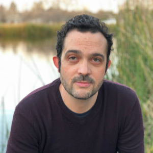 Headshot of Prof. Chris Arnold with a lake in the background