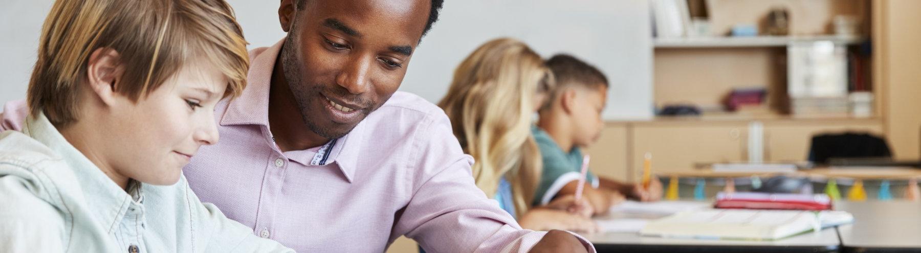 Male teacher teaching a student in the classroom